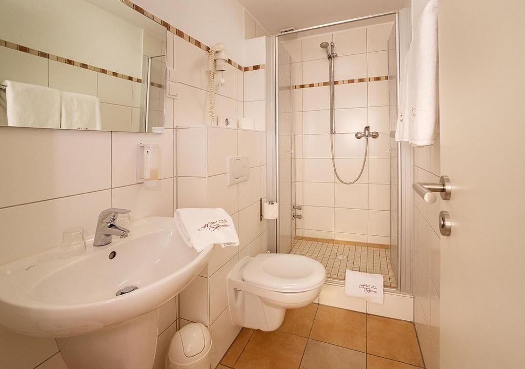 Ein Badezimmer mit Waschbecken, Toilette und Dusche.