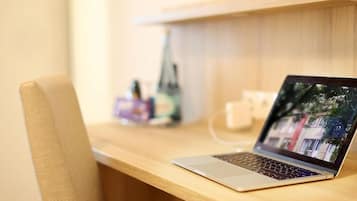 Una computadora portátil sobre un escritorio de madera, con un fondo desenfocado.