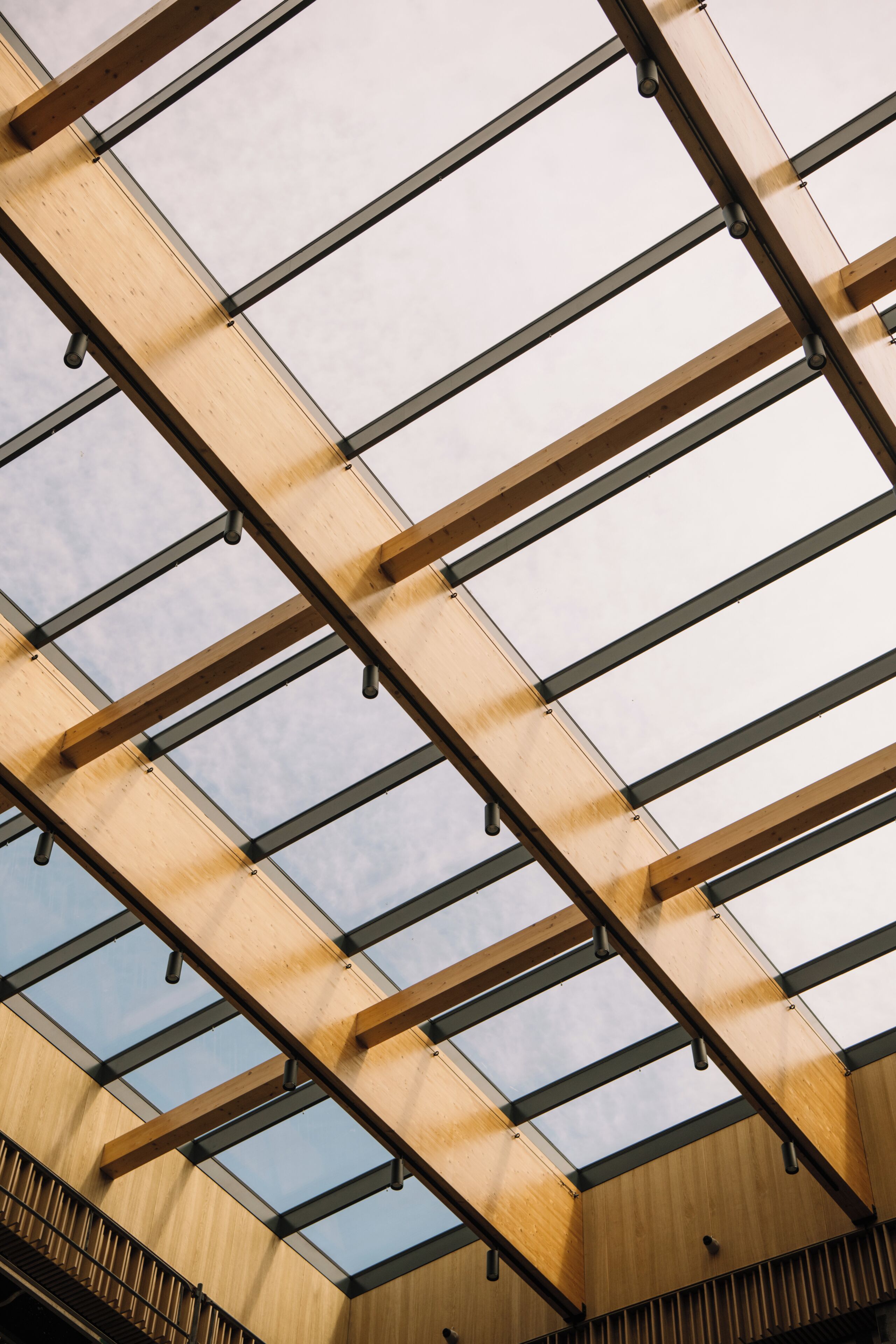 A modern building's interior with a wooden ceiling and skylights.