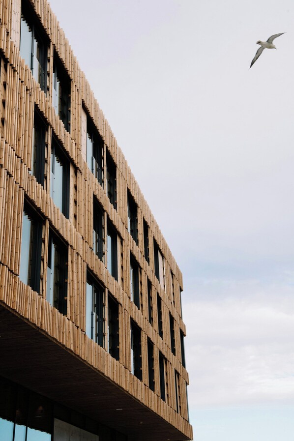 Un edificio moderno con fachada de madera y varias ventanas.