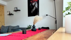 A wooden table with a red cloth, two black vases, and a plant.