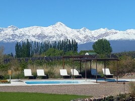 Una piscina al aire libre de temporada, sillones reclinables de piscina