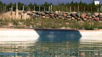 En säsongsöppen utomhuspool och solstolar