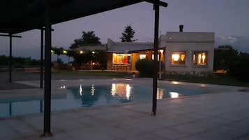 Una piscina al aire libre de temporada, sillones reclinables de piscina