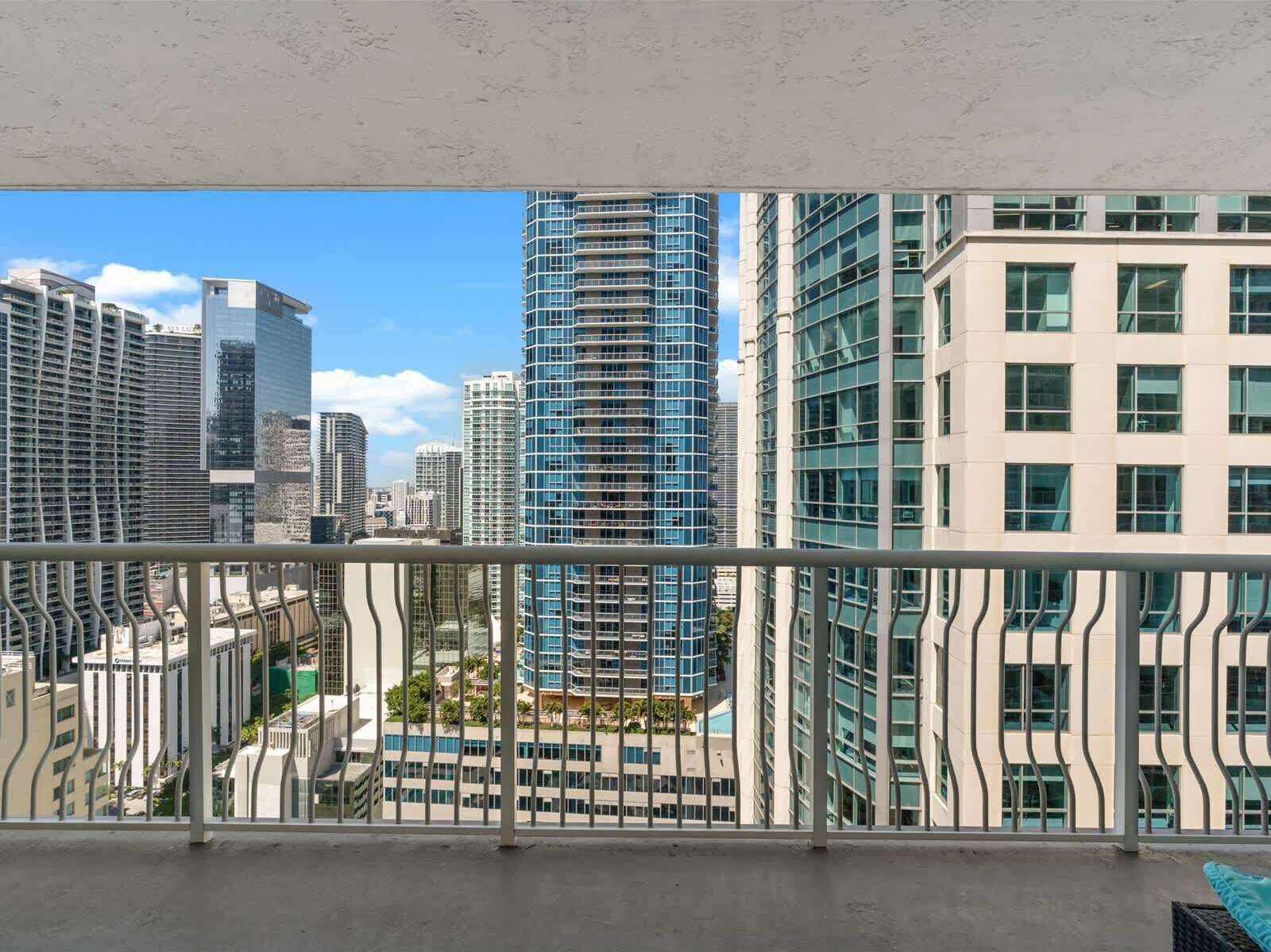 A high-rise building with a modern design, large windows, and a view of other buildings.