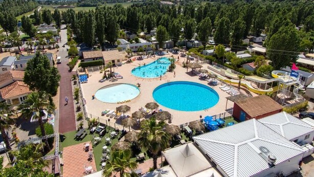 A resort with two large swimming pools, a water slide, and a view of the surrounding landscape. - 6 person mobile home "La Pagode" in a family campsite**** (Fréjus)