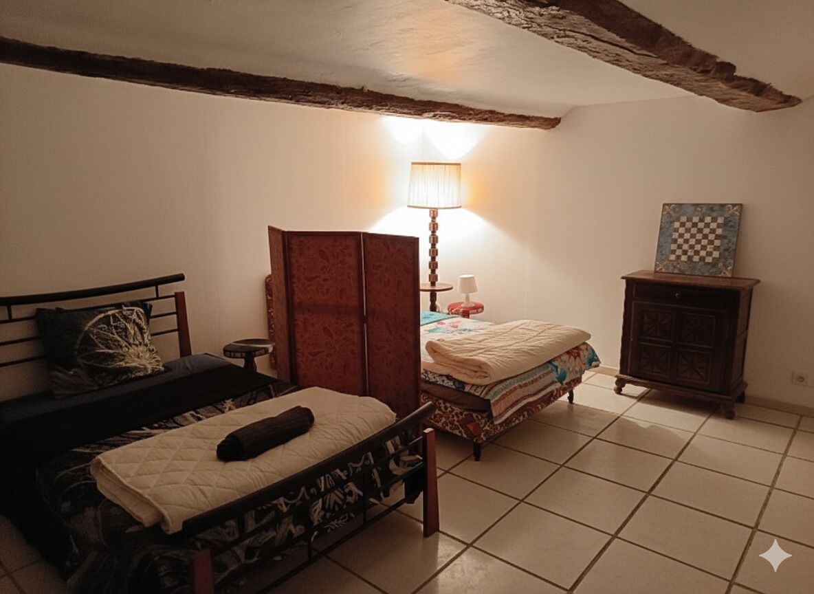 Ein Schlafzimmer mit zwei Betten, einem Kleiderschrank, einer Lampe und einem karierten Bild an der Wand.