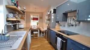 A modern kitchen with wooden countertops, a built-in oven, and a stainless steel refrigerator. - Mill View Cottage- charming coastal cottage (Saint Monans)