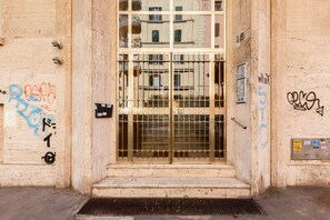 A building entrance with a metal gate, steps, and graffiti on the walls. - Karolina's Home, 2-BDR @Vatican (Roma)