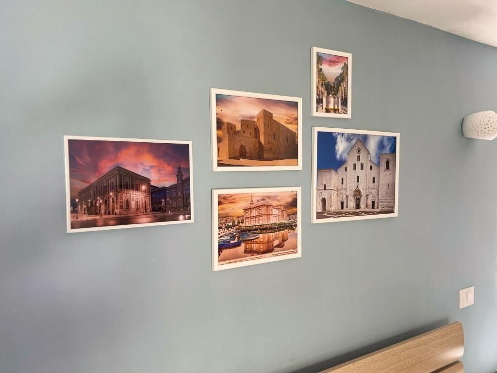 A wall with five framed photographs of buildings.
