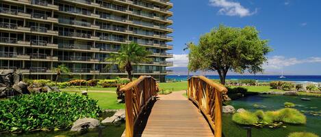 A wooden bridge leading to a hotel with a view of the ocean.