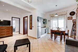 Eine moderne Wohnung mit Wohnzimmer, Essbereich, Küche und Fernseher.
