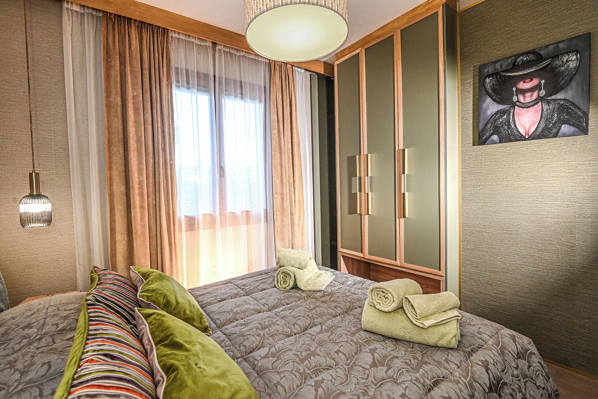 Une chambre à coucher avec un lit, une armoire et un tableau accroché au mur.