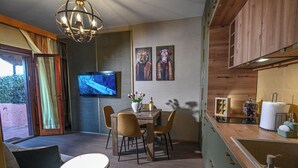 A dining area with a table, chairs, and a television. - Accogliente appartamento situato a Olbia,
A 2 km dall'aeroporto.. (Olbia)