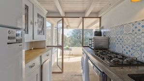 Cucina con forno, lavatrice e zoccolo in piastrelle.