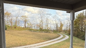 Eine überdachte Veranda mit Blick auf eine Rasenfläche und einen gewundenen Weg.