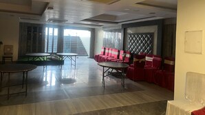 A conference room with a large table, red chairs, and a padded wall. - Staylo Masterprice Palace (Lucknow)