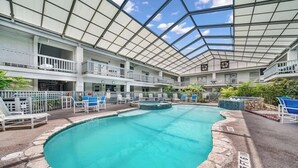A large indoor pool with a glass ceiling, multiple balconies, and lounge chairs. - Cozy Beach Retreat Near Whitecap & Padre Island (Corpus Christi)