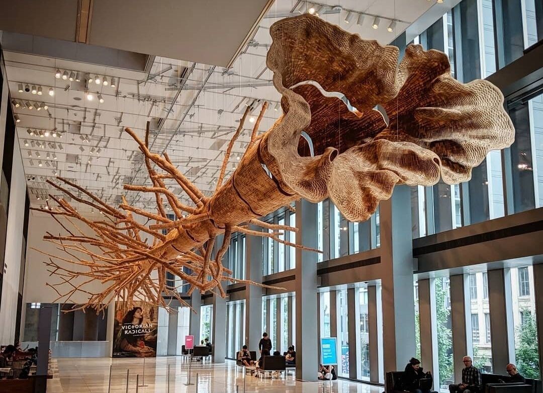 A spacious lobby with a large, abstract sculpture hanging from the ceiling.