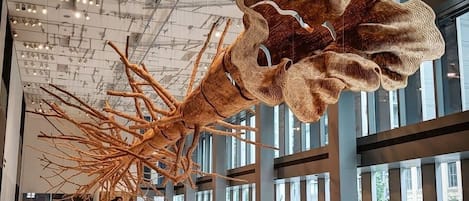 En rummelig lobby med en stor, abstrakt skulptur hængende i loftet.
