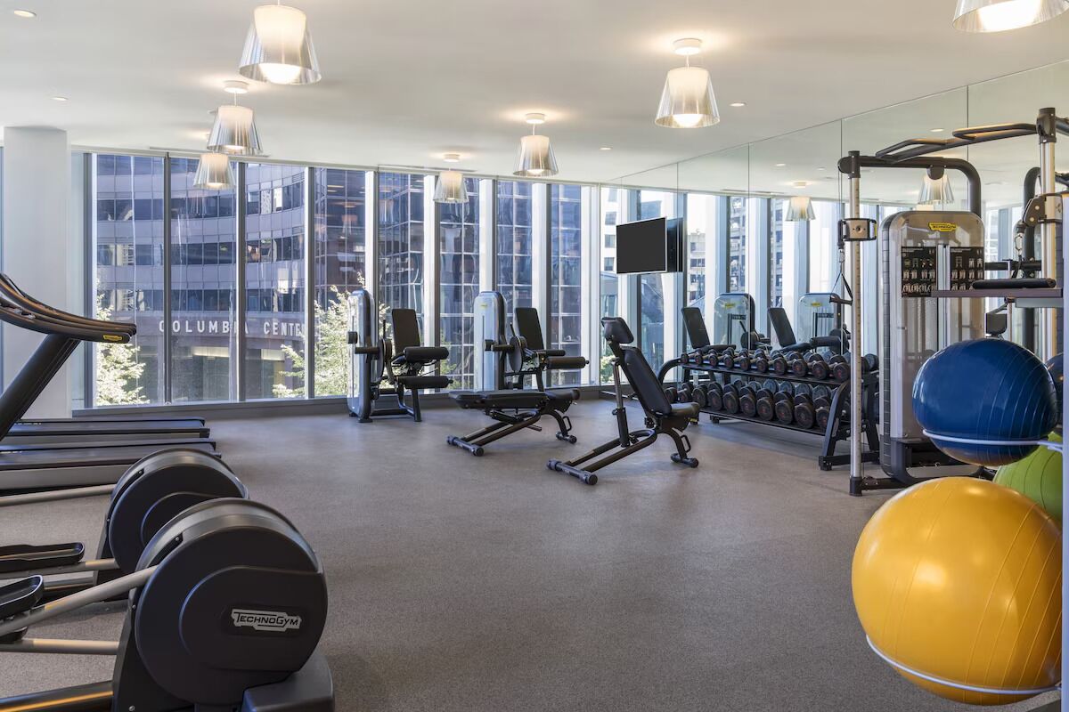A gym with cardio equipment, weight machines, and exercise balls.