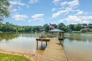 A wooden dock extending into a lake with a gazebo and lounge chairs. - Waterfront Home with Hot Tub, Fire pit, Kayaks, SUP and Private Dock (Mooresville)