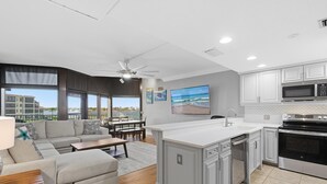A modern kitchen with white cabinets, a large island, and stainless steel appliances. - Marker 33 #2d3 (New Smyrna Beach)