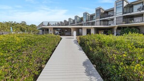 A modern building with multiple balconies and a central walkway. - Marker 33 #2d3 (New Smyrna Beach)