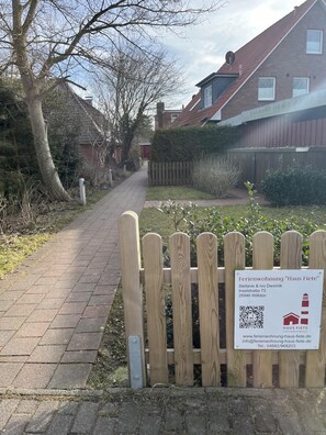A pathway leading to a property named 'Haus Fiete' with a wooden fence and a signboard. - Small Fiete vacation apartment (Wittdün)