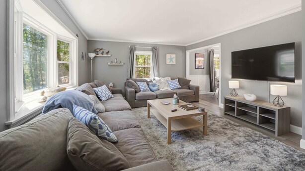 Een woonkamer met een modulaire bank, een salontafel, een televisie en een open haard.