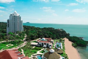 Ein Resort mit einem großen Gebäude, einem Strand und einem Poolbereich.
