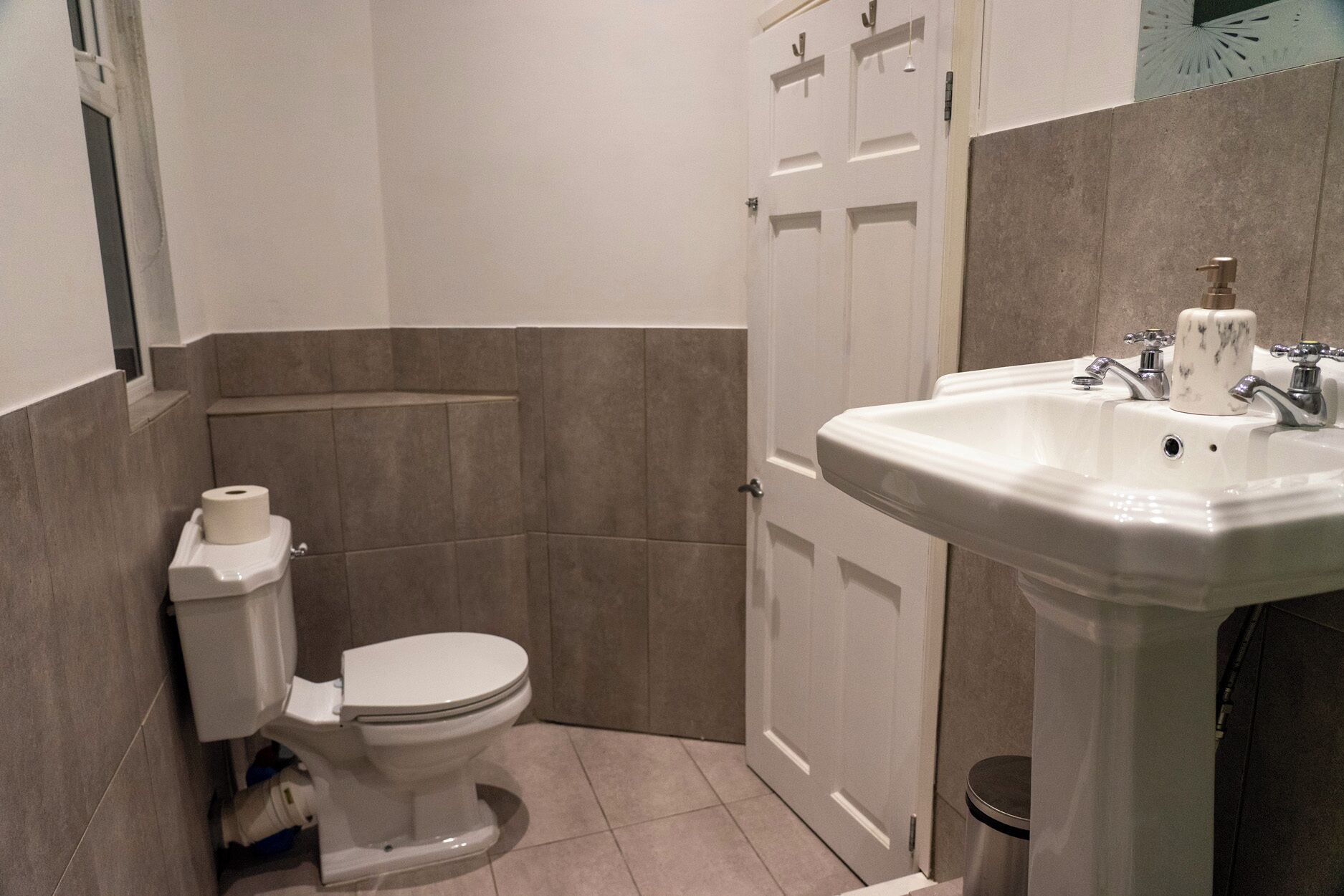 Un baño pequeño con inodoro, lavamanos y espejo.