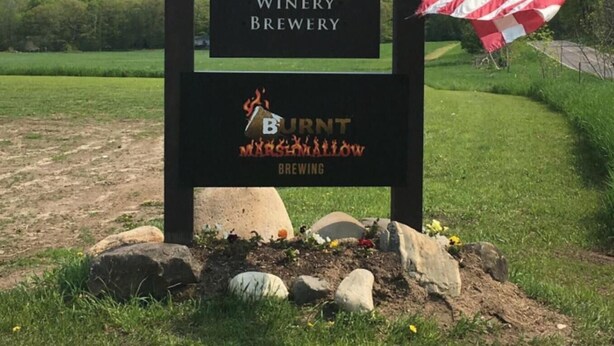 Señal de Rudbeckia Winery & Brewery con una bandera estadounidense.