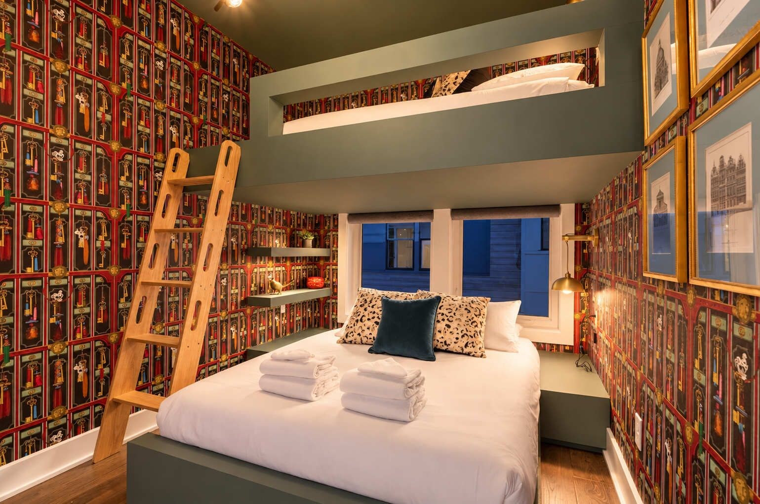 Ein Schlafzimmer mit einem Etagenbett, einer Halterung, einem Bücherregal und einem Fenster mit Blick.