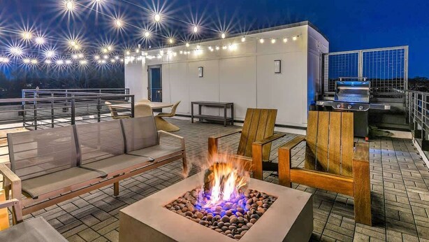 A rooftop patio with outdoor seating, a fire feature, and a grill. - Designer 3BR Nash Home w/ Private Rooftop Fire Pit (Nashville)
