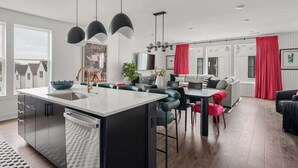 A modern kitchen with a central island, stainless steel appliances, and pendant lighting.