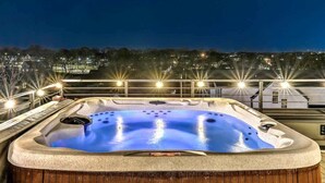 A hot tub with a view of a cityscape at night.