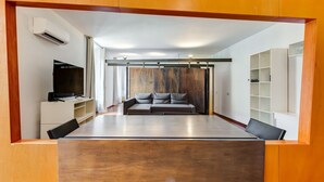Un salon moderne avec un canapé, un téléviseur et des étagères intégrées.