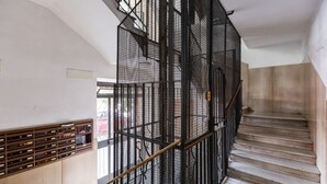 Un escalier avec une rampe en métal et une main courante en bois.