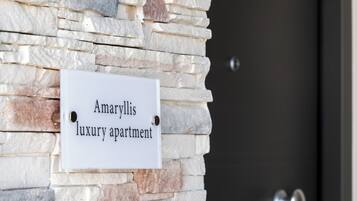 A sign on a stone wall that reads "Amaryllis luxury apartment."