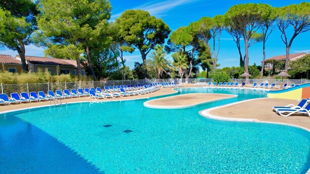 A clear blue pool with blue lounge chairs and trees in the background. - Côté Terrasses, 4 pers Piscine à Calvisson (Calvisson)