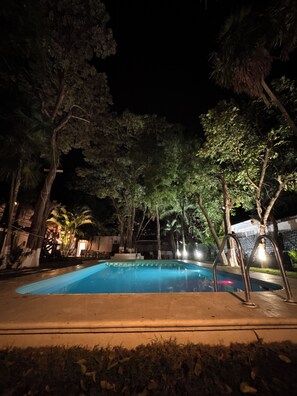 A swimming pool surrounded by trees at night. - Marelle Hotel Boutique (Playa del Carmen)