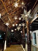 Un pasillo con vigas de madera y luces colgantes con forma de estrella.
