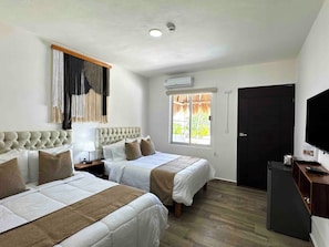 A hotel room with two beds, a TV, a window with a view, and a door. - Marelle Hotel Boutique (Playa del Carmen)
