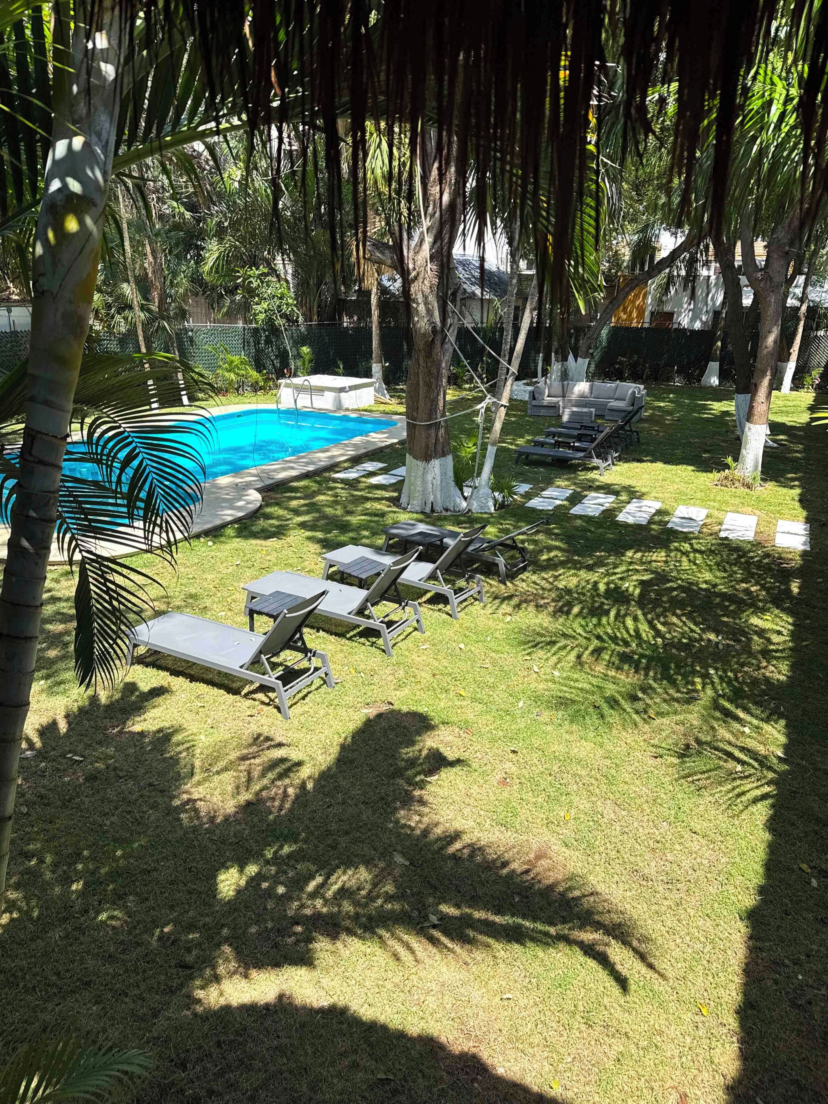 A pool area with lounge chairs and a small pool.