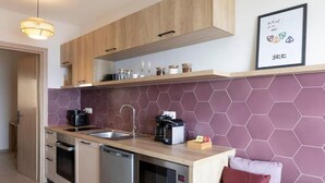 Una cucina moderna con mobili in legno, un forno a microonde, una macchina da caffè e un lavello.