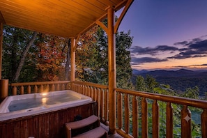 A wooden deck with a hot tub and a wooden bench, overlooking a mountainous landscape. - A Cozy Smoky Mountain Escape w/ Views (Sevierville)