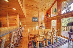 A wooden interior with a large dining table and chairs, wooden walls, and large windows. - Amazing Smoky Mountain Views w/ Hot Tub (Sevierville)