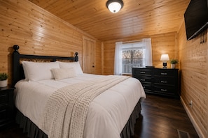 Un dormitorio con paneles de madera, una cama, un tocador y una ventana.