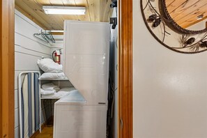 Ein kleines Zimmer mit Etagenbetten, einer Waschmaschine und einem fest montierten Heizkörper.